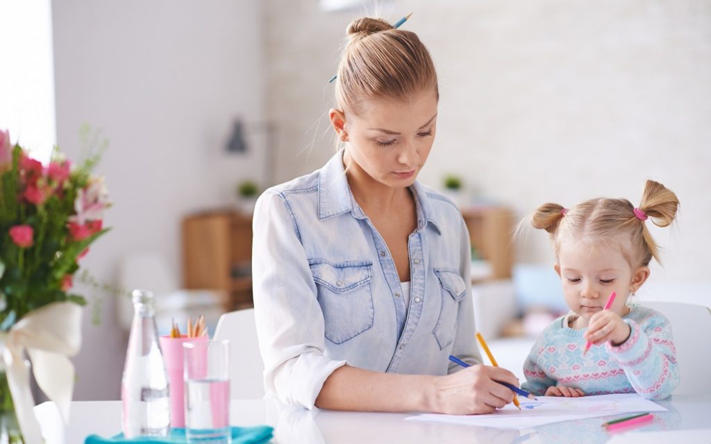 Little girl and her mother drawing together